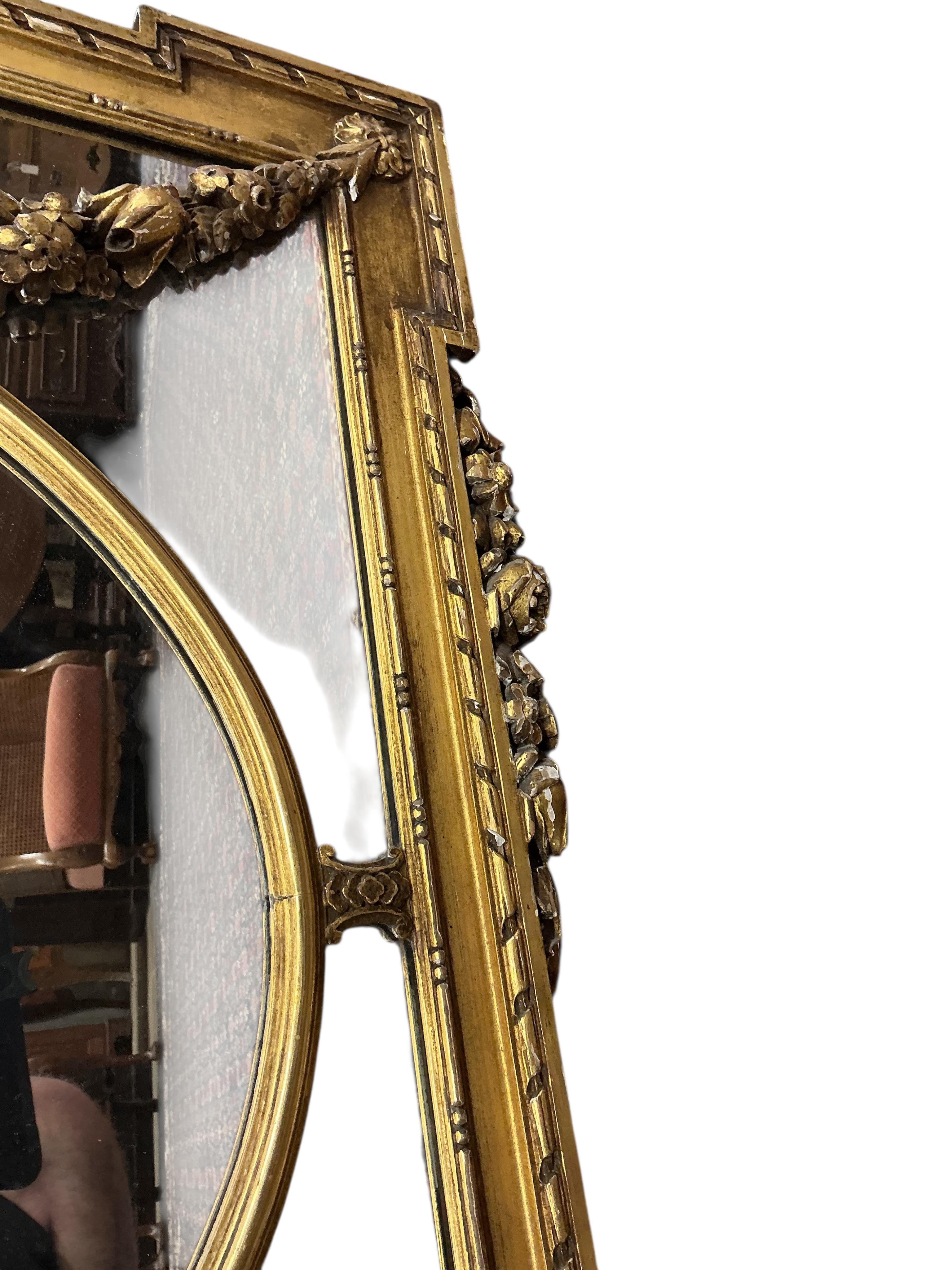 A Victorian style giltwood and composition overmantel mirror with cross torch and quiver crest, width 136cm, height 110cm
